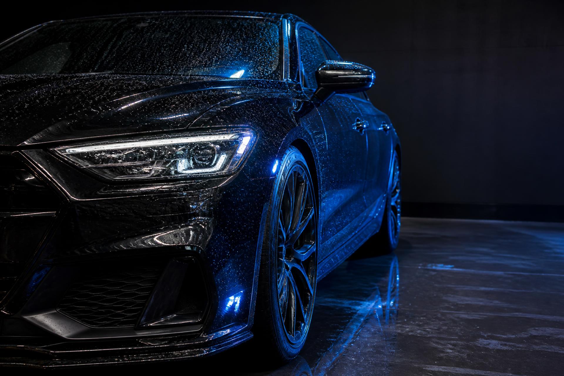 Gloss black performance car being professionally detailed by hand